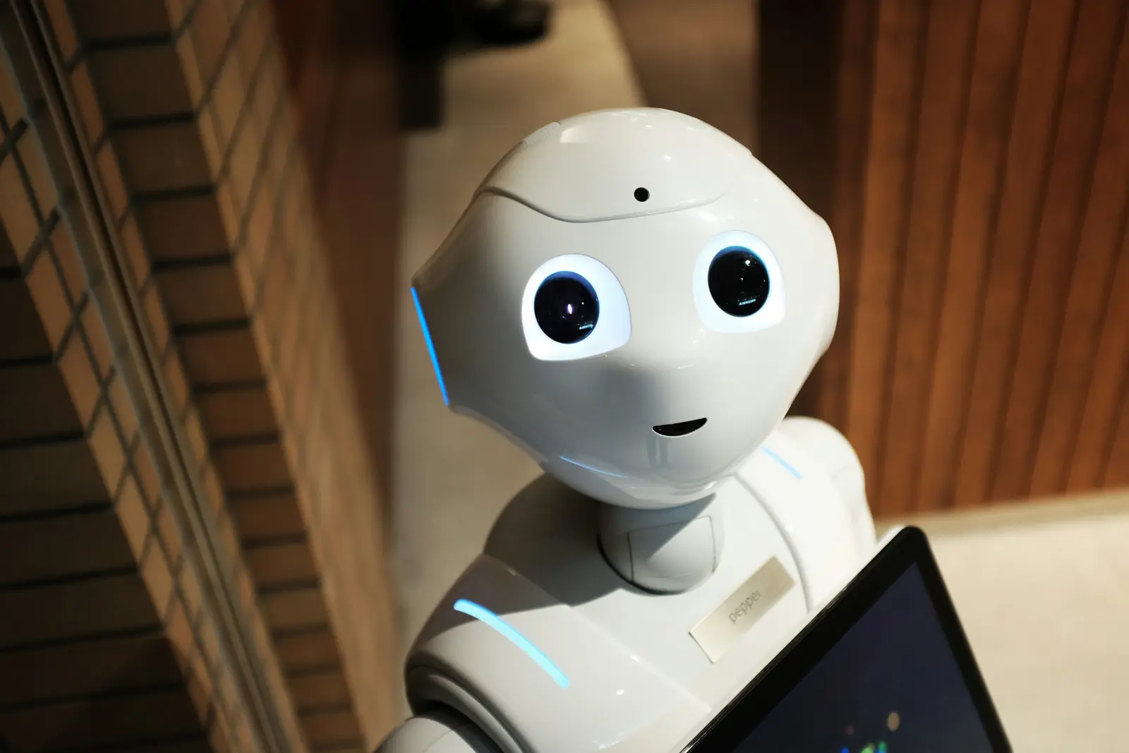 Un robot humanoïde face à une tablette : l'interaction entre humains et machines.